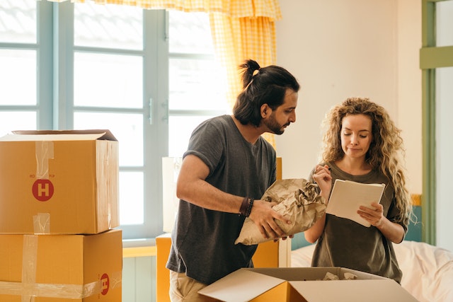a%20couple%20moving%20into%20an%20apartment%20and%20looking%20over%20a%20checklist